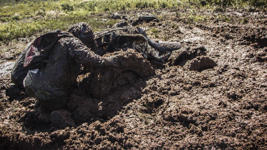 man and atv in the mud