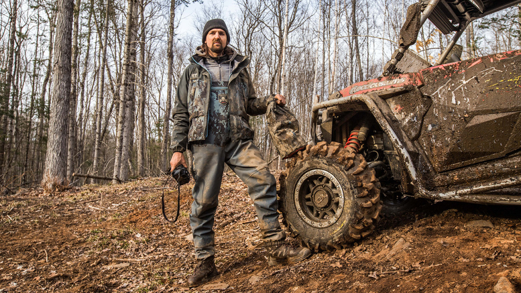 utv with a deep scratch and rider in mud