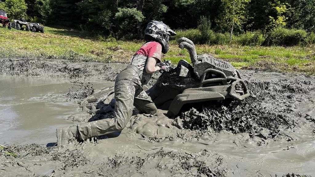 girl rides atv in mud