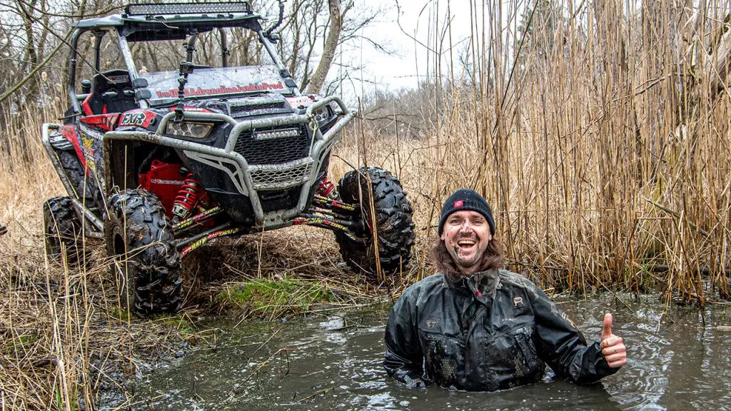 man and atv in a swamp
